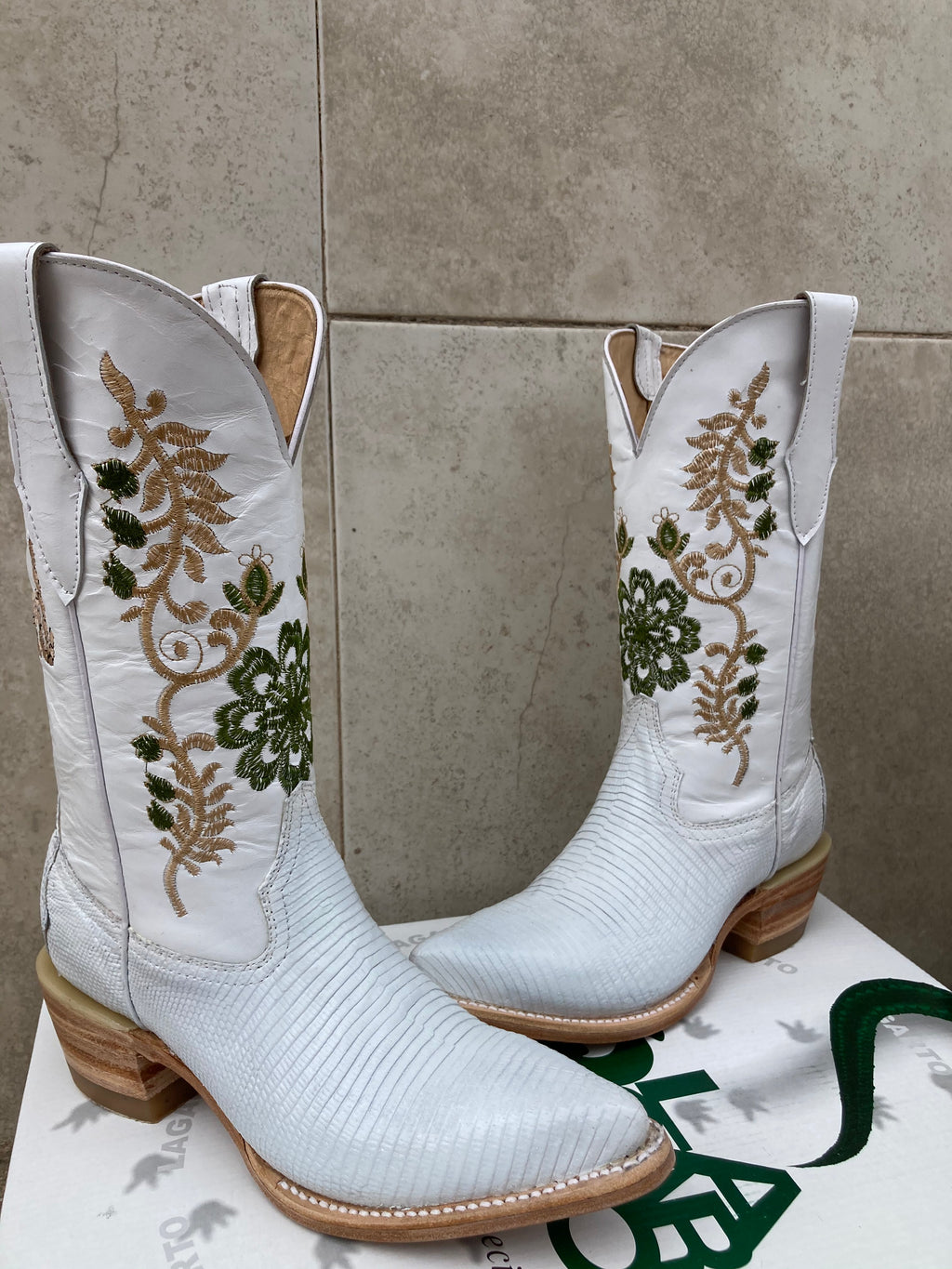A custom made pair of white cowboy botos made for a wedding using white lizard skin with custom embroidery